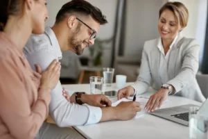 happy man and his wife having meeting with financial advisor and signing an agreement in the office 1030x687 1